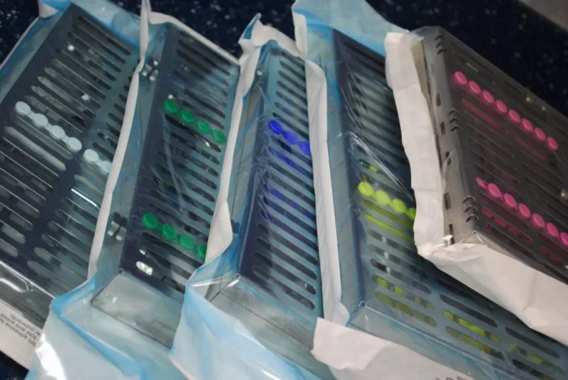 Sterilization cassettes containing dental instruments sealed in individual pouch packaging.
